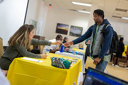 A student browses through work-study opportunities at the Student Employment Job Fair.