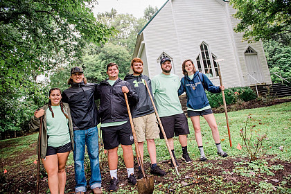 Students clean up the grounds of a local church during Service Plunge.