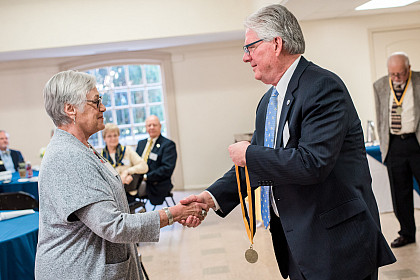 President Schrum presents medals to members of the class of 1968.