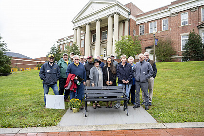 A group of alumni stand in front of Wiley Hall