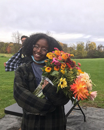 A student holds a bouquet of flowers from the garden.