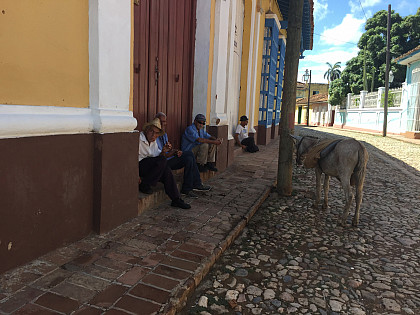 Locals enjoying their day in Trinidad, Cuba, a place known for its cobblestone streets and long colonial history.