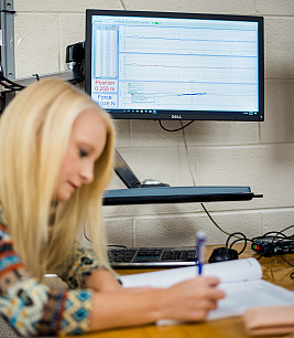 Student in front of computer screen showing graphs from data acquisition software