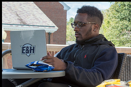 Student using laptop outside Kelly Library.