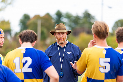 Coach Tom O'Neill with players during a match.
