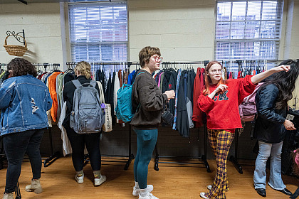 A volunteer Thrift Store worker assists a student shopper in locating an item.