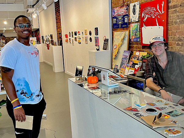 two gentlemen talking in an art store.