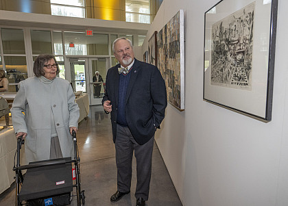 Attendees viewing art exhibited at the McGlothlin Center for the Arts in the reception area.