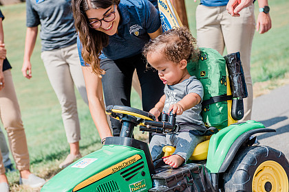 Zavier tries out his tractor with help from a student.