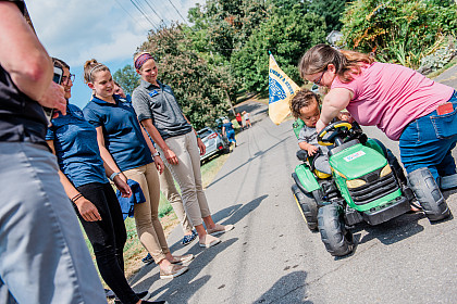 Students with Zavier and his mother as he rides the tractor.