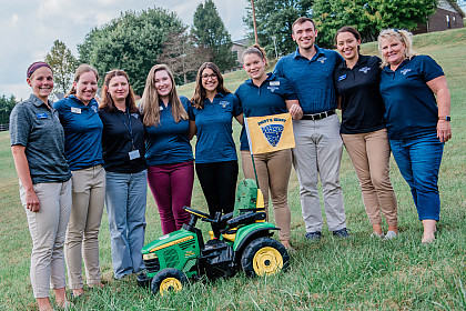 Students and faculty stand with the modified tractor.